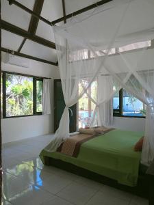 吉利特拉旺安吉利世外桃源酒店的一间卧室配有一张带天蓬的绿色床