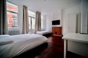 布鲁塞尔Smart Appart - Bossaerts的一间白色卧室,配有床和电视
