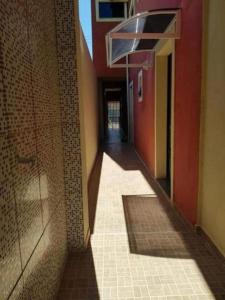 瓜拉图巴Apartamentos na Quadra do Mar的建筑的空走廊,铺着瓷砖地板