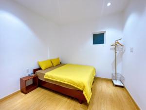 龙川市Lá Homestay Apartment的一间卧室配有一张黄色毯子床