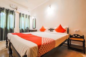 ChicolnaOYO La Petite Near Dabolim Airport的一间卧室配有一张带橙色和白色床单的大床