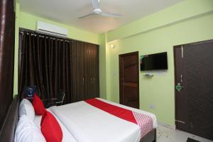 巴特那Flagship Near Anisabad Golambar的一间卧室配有一张带红色枕头的床