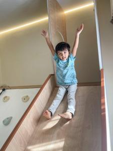 努沙再也KidsVille Slide Family Oasis JB Medini Legoland Malaysia的小孩坐在楼梯底部