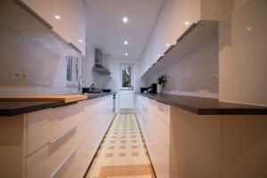 布鲁塞尔Smart Appart - Bossaerts的厨房配有白色橱柜和黑色台面