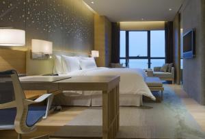 重庆 重庆解放碑威斯汀酒店的一间卧室配有一张大床、一张桌子和一张书桌