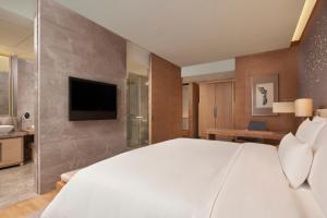 重庆 重庆解放碑威斯汀酒店的卧室配有一张白色大床和电视。