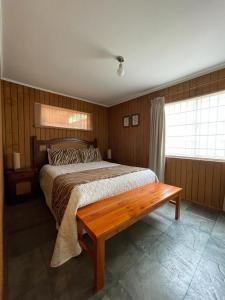 里坎雷Casa Lican Ray的一间卧室配有一张床和长凳