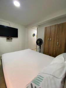 卡利Apartamentos en el Norte de cali的卧室配有白色的床和平面电视。
