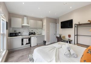 伦敦Brand New Homey and Stylish Perfect for Travellers的一间带白色床的卧室和一间厨房