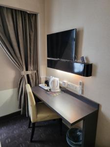 吉隆坡Avaria KL的一张桌子,位于酒店的房间,配有椅子和电视