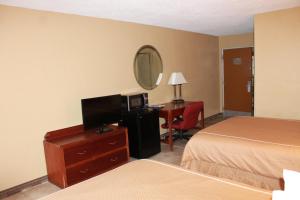 琼斯伯勒Fairview Inn & Suite的酒店客房设有一张床和一张带电视的书桌。