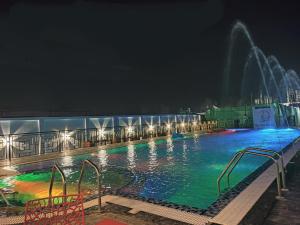 曼达莫尼THE PELICAN BEACH RESORT的游泳池在晚上设有喷泉