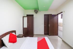贾姆穆OYO Flagship 62748 Hotel Zeenat的一间卧室配有一张红色枕头的床