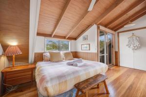 Goughs BayWollondilly - Mansfield - Sleeps 10的一间卧室设有一张大床和木制天花板。