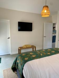 Erowal BayErowal Bay Guesthouse Jervis Bay的一间卧室配有一张床和一台平面电视