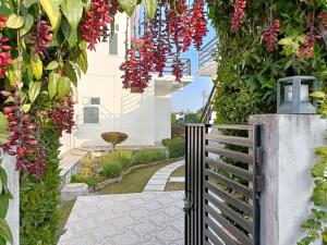 JhirnaHriday Bhoomi - Luxury Cottages & Villa in Jim Corbett的花园种有红色的鲜花,设有围栏