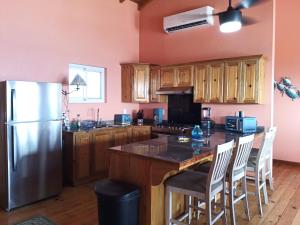 乌蒂拉Casa Corazon Striking Beach Home的厨房配有不锈钢冰箱和木制橱柜