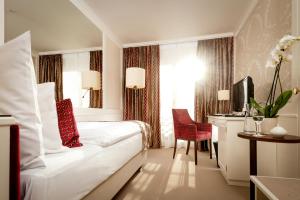 瓦杜兹Park Hotel Sonnenhof - Relais & Châteaux的酒店客房设有白色的床和窗户。