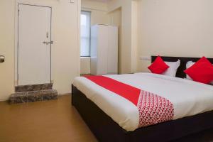 海得拉巴Alpine glow Zenith的一间卧室配有一张带红色枕头的大床
