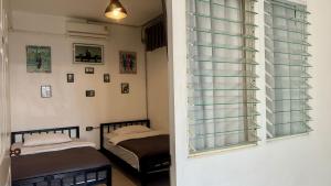清莱Backpack Hostel的一间卧室设有两张床和窗户。