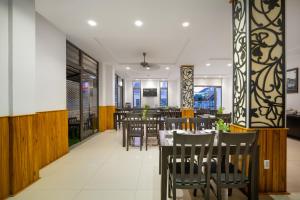 会安RAON Hoian Beach的餐厅拥有木墙和桌椅