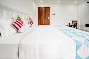 布巴内什瓦尔Sayhallo Prime Residency的卧室配有带枕头的大型白色床