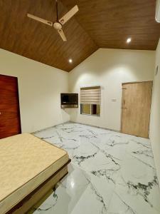 罗纳瓦拉Tara's Hill Resort的一间铺有大理石地板的卧室和天花板