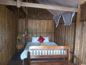 Phumĭ Kaôh ÂndêtTatai Natural Resort的一间卧室配有一张红色枕头的床
