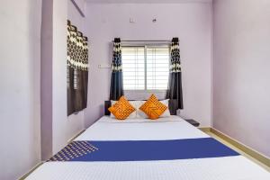 BhandāraSPOT ON The Highway Inn的一间卧室配有一张带橙色枕头的大床