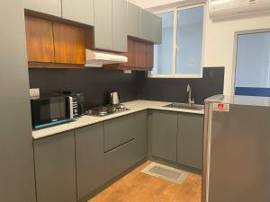 拉维尼亚山Rush Resident Mount Lavinia的厨房配有灰色橱柜、水槽和微波炉