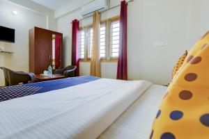 德拉敦SPOT ON Chandra's Residence的卧室配有一张床和一张桌子及椅子