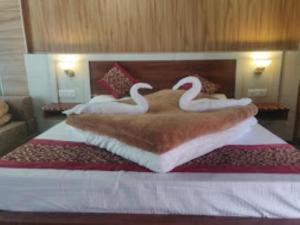 巴德里纳特Hotel Badrinath Anant Badrinath的两间天鹅在旅馆房间床上