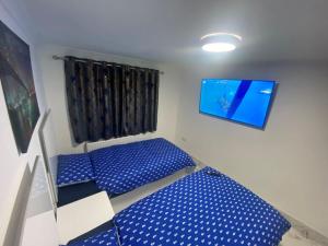 海斯THE ROYAL BOUTIQUE OXFORD LODGE by LONDON SLEEP 8的客房设有2张蓝色的床和平面电视。