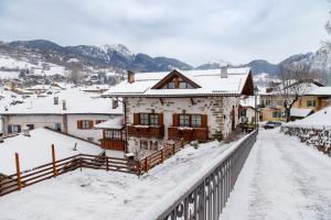 菲耶梅堡科拉迪尼食宿酒店的村庄的房屋被雪覆盖