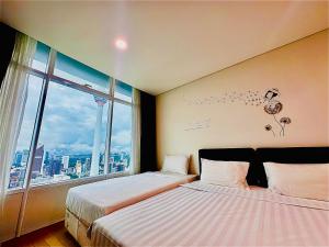 吉隆坡Vortex Suites KLCC by UNIQUE的带大窗户的客房内的两张床