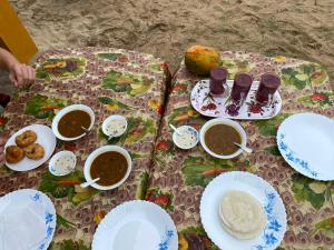阿勒皮Marari Sunset Beach Villa的桌上放有盘子和碗的食物