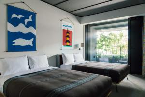 京都Ace Hotel Kyoto的一间卧室配有两张床,并画有海豚