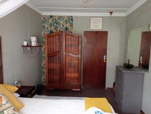 KestellCampbell Stays的一间卧室配有床、木制橱柜和门