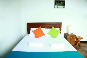 康提Eden Rock Luxurious Accommodation的一间卧室配有带色彩缤纷枕头的床。