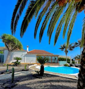 洛斯·亚诺斯·德·阿里丹Villa Tajuya的一座别墅,设有游泳池和棕榈树