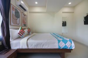 KalamboliHome Exotic Studio Kalamboli的一间卧室配有带白色床单和枕头的床。