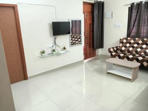 蓬蒂切里Rose Villa Pondicherry的带沙发和电视的客厅