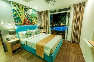 公主港阿齐扎天堂酒店 的酒店客房设有一张床,墙上挂有绘画作品