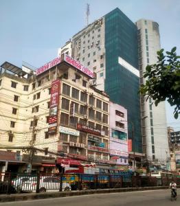 达卡Hotel In Need - Near to the US and Canada Embassy in Dhaka的一座高大的建筑,上面有城市标志