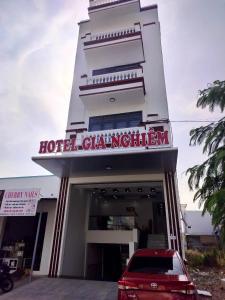 Ấp Cái GiáKhách sạn Gia Nghiêm 2的酒店大楼前有一辆红色的汽车
