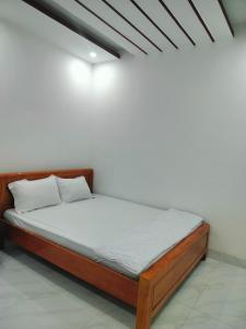 Ấp Cái GiáKhách sạn Gia Nghiêm 2的白色墙壁间的一张床位