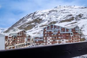 蒂涅Belambra Clubs Tignes Val Claret的雪覆盖的山前的一组建筑