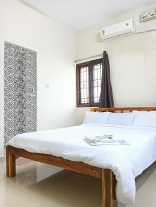 蓬蒂切里Rose Villa Pondicherry的白色卧室配有白色床单