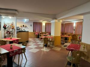 福尔加里亚Life Hotels Des Alpes的一间在房间内配有桌椅的餐厅