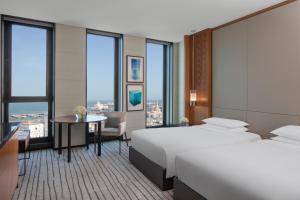 多哈Park Hyatt Doha的酒店客房设有一张大床和一张书桌。